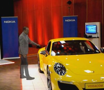 A Hologram of a man standing in front of a Porsche